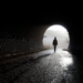 A lone figure walking through a dark tunnel toward bright light, symbolising healing, release, and emerging strength after hardship.