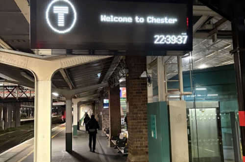 Chester railway station late at night, with a sign reading “Welcome to Chester” at 22:39, during a long journey home.