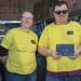 Mark Jones and Debbie Fretwell at The Hygiene Bank North Wales storage facility, standing beside shelves of donated hygiene products.